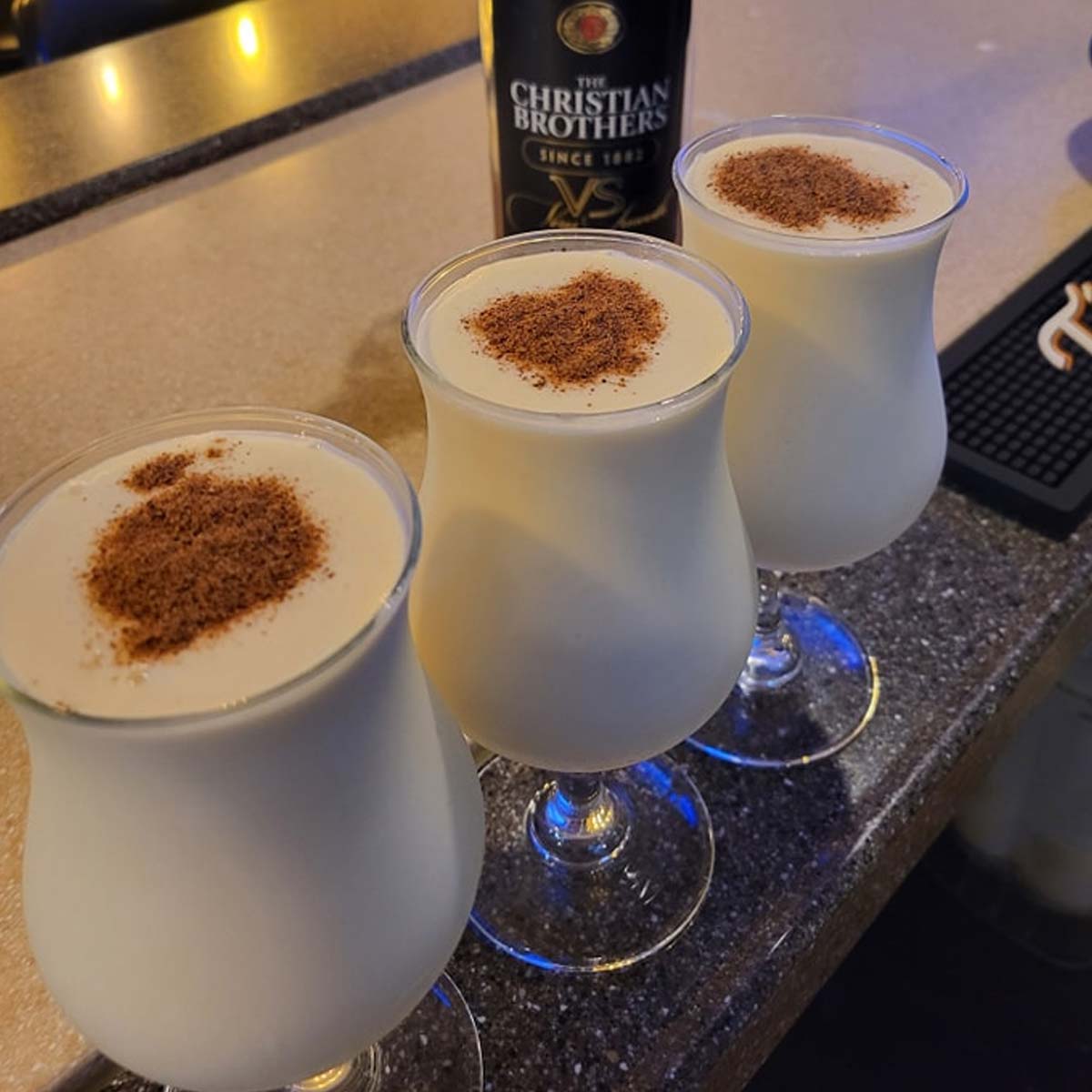 A group of glasses with white liquid and brown sprinkles are ready to enjoy at The Granary Supper Club, known for the Best Food near Sherwood Bar.